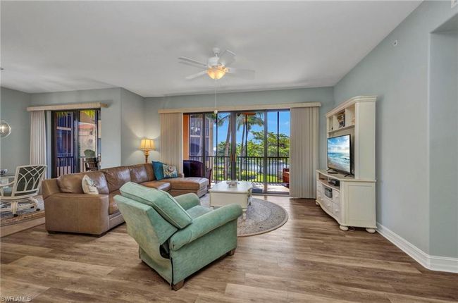 Living room with a ceiling fan and wood finished floors | Image 8