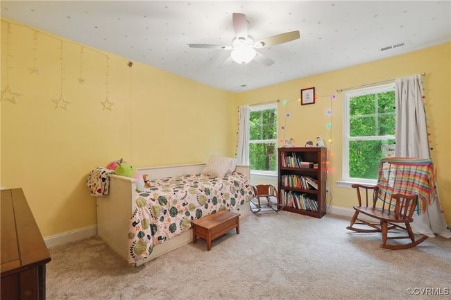 Spacious upstairs bedroom with large windows and peaceful wooded views. | Image 25