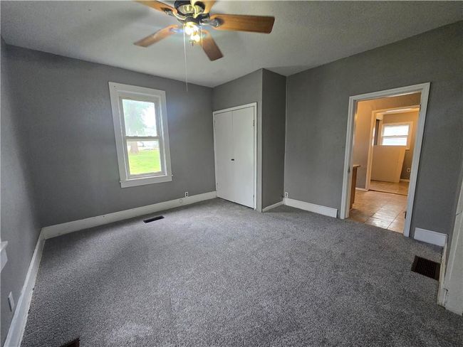 Unfurnished bedroom with multiple windows, carpet, baseboards, and ceiling fan | Image 21
