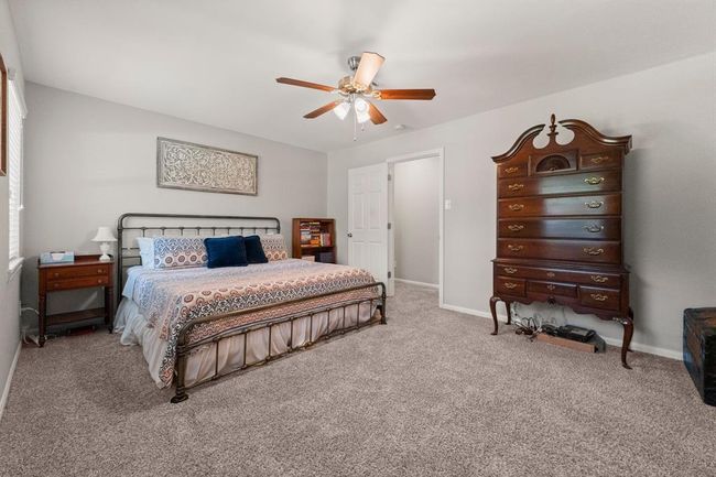 Spacious bedroom features ample natural light, creating a cozy and inviting atmosphere. | Image 26