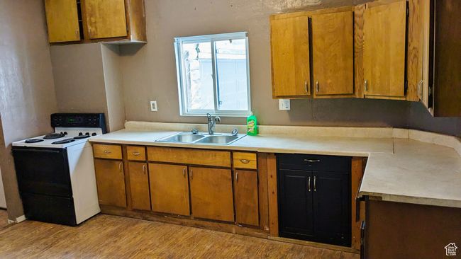 Kitchen with sink, light hardwood / wood-style flooring, and white electric stove | Image 34