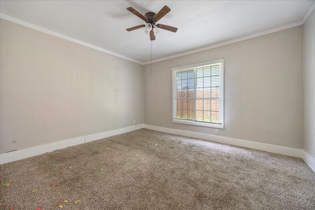 Carpeted empty room featuring ornamental molding and ceiling fan | Image 6