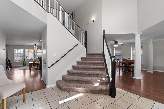 The stairway split one side going into the living area and the other to the foyer. | Image 22