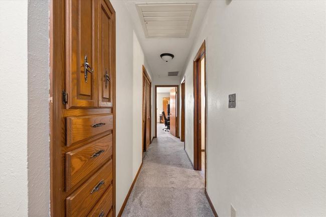 Hallway with light carpet and baseboards | Image 26
