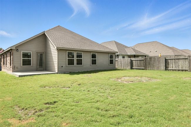 Rear view of house with a shingled roof and a patio area | Image 34