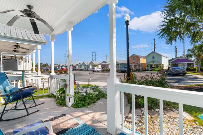 Covered porch featuring a ceiling fan and a residential view | Image 5