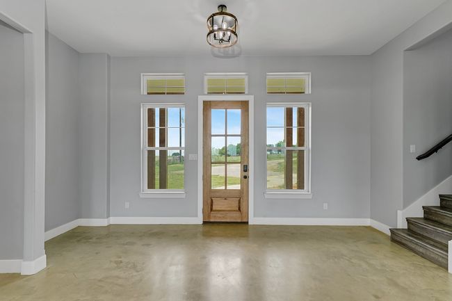 Entryway with concrete floors, baseboards, and stairs | Image 6