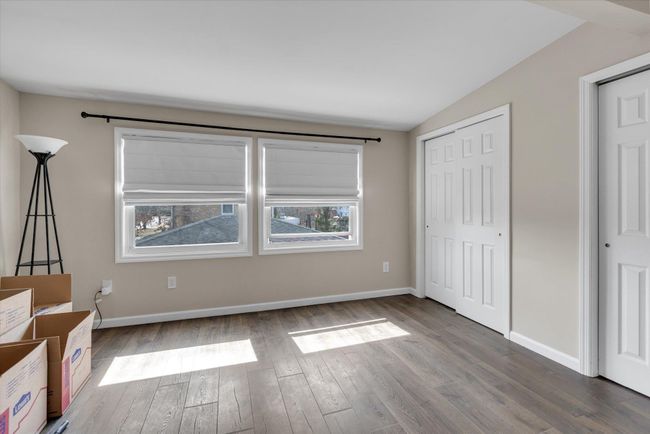 Unfurnished bedroom with wood finished floors, baseboards, and a closet | Image 11