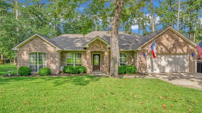 This is a single-story brick home with a two-car garage. | Image 1