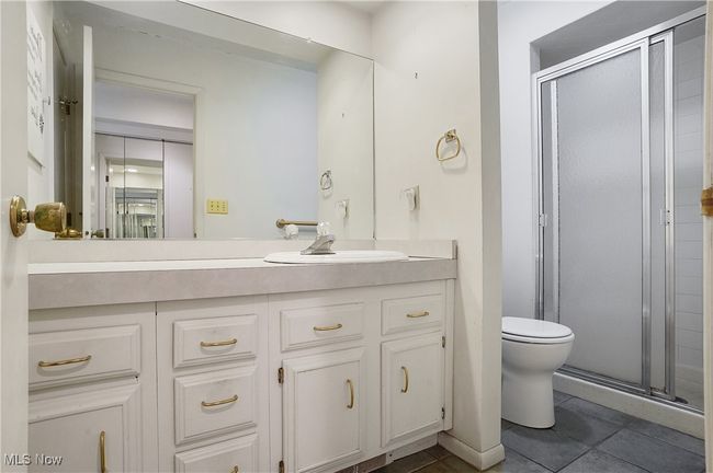 Full bath with a shower stall, toilet, tile patterned flooring, and vanity | Image 31