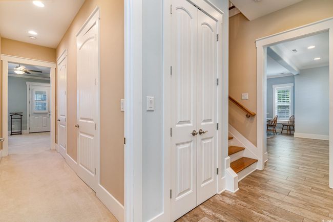 Corridor with light wood finished floors, baseboards, recessed lighting, and stairs | Image 25