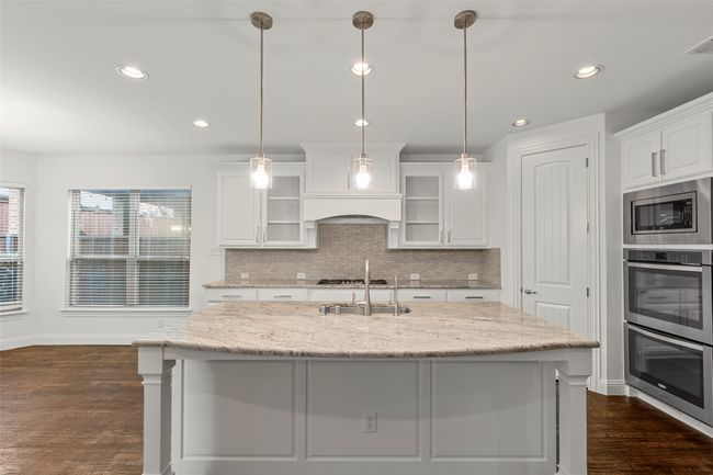 Kitchen featuring a sink, stainless steel appliances, baseboards, tasteful backsplash, and dark wood-style floors | Image 12