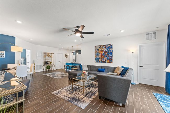 Modern layout featuring a large sectional, statement art, ceiling fan, and stylish finishes for everyday comfort and entertaining. | Image 7