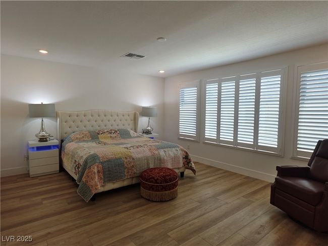 Bedroom featuring baseboards, visible vents, wood finished floors, and recessed lighting | Image 32