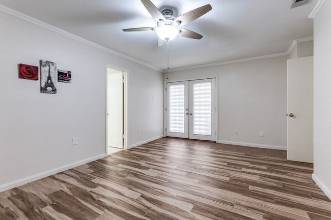 Spare room with french doors, a ceiling fan, wood finished floors, and crown molding | Image 18