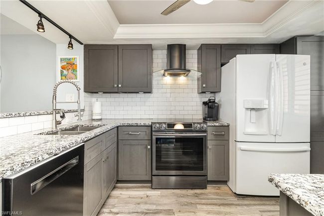 BEAUTIFULLY UPDATED KITCHEN. CABINETS. GRANITE COUNTERTOPS. UNDER-MOUNT STAINLESSFULL-HEIGHT SUBWAY TILE BACKSPLASH. MODERN HOOD W/LIGHTING. | Image 9