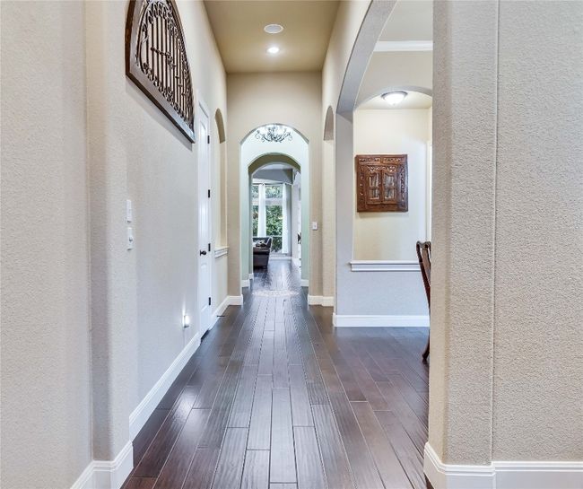Corridor with arched walkways and dark wood-style floors | Image 8