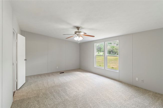 Carpeted spare room with ceiling fan and visible vents | Image 21