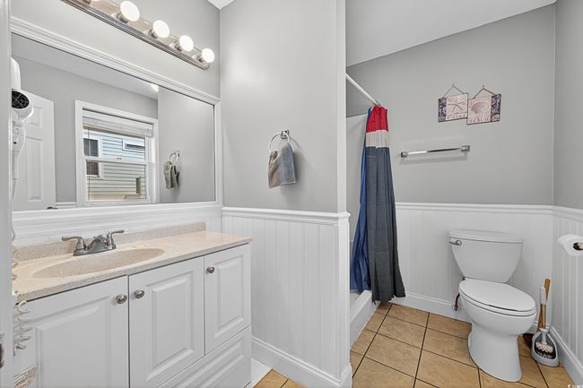 Full bath featuring vanity, wainscoting, tile patterned flooring, and a shower with curtain | Image 23