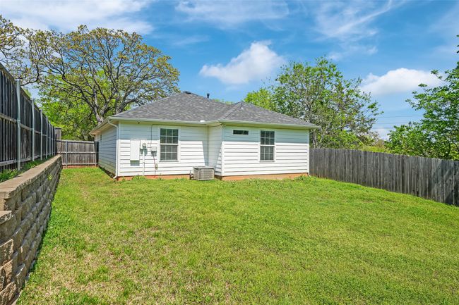 Rear view of house featuring roof with shingles, a yard, and a fenced backyard | Image 32