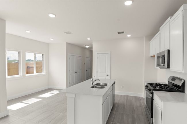 Kitchen featuring visible vents, baseboards, recessed lighting, a sink, and appliances with stainless steel finishes | Image 16