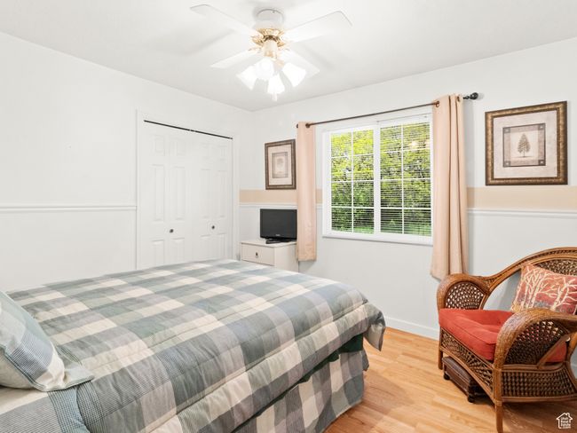 Bedroom featuring a ceiling fan light wood-style floors, and a closet | Image 13