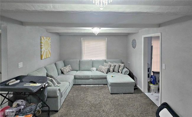 Living area featuring beam ceiling and carpet flooring | Image 15