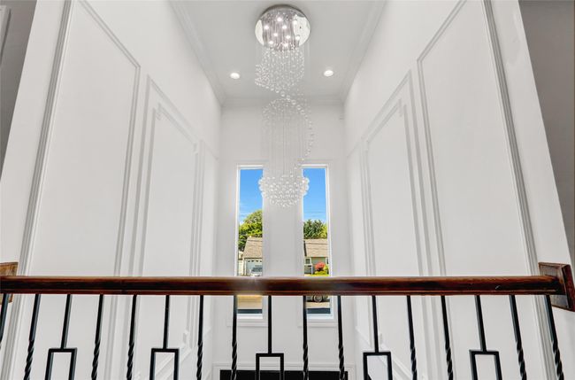 Detailed view of a chandelier, ornamental molding, recessed lighting, and a decorative wall | Image 26