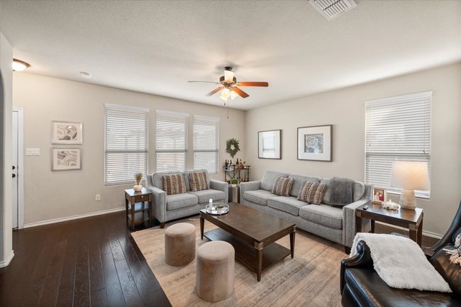 Living room with baseboards, a ceiling fan, visible vents, and hardwood / wood-style flooring | Image 21