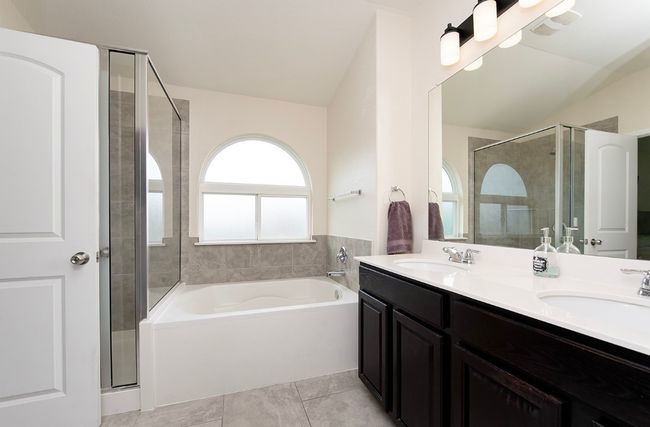 Bathroom with a shower stall, a garden tub, double vanity, and lofted ceiling | Image 15