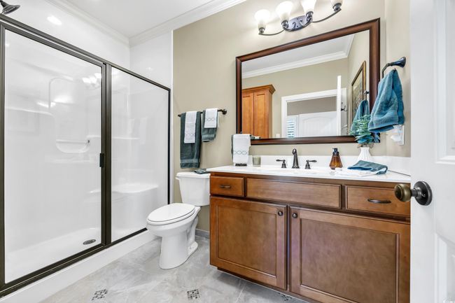 Bathroom with ornamental molding, a shower stall, toilet, and vanity | Image 16