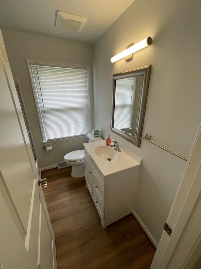 Bathroom with wood finished floors, visible vents, vanity, and toilet | Image 25
