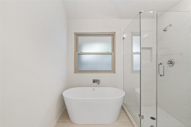 Tiled shower and large window bring in light while keeping privacy and functionality. | Image 17