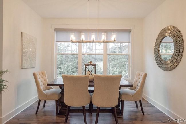 Dining room featuring healthy amount of natural light, dark wood-style flooring, and a chandelier | Image 32