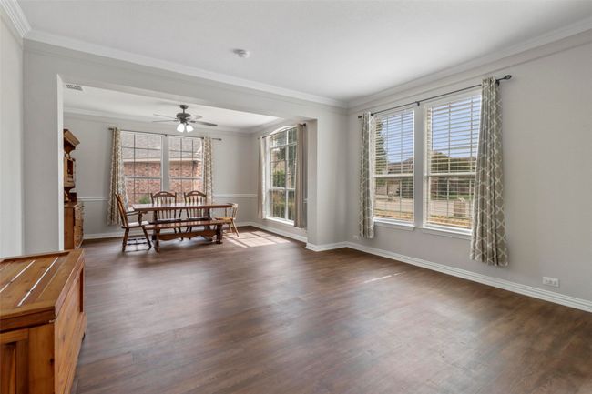 Dining area featuring dark wood-style flooring, a ceiling fan, and ornamental molding | Image 7