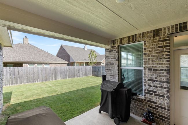 Fenced backyard with a patio area | Image 27