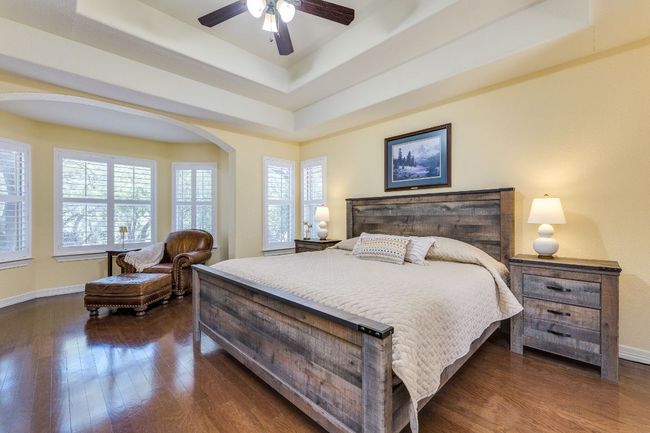 Primary bedroom featuring a tray ceiling, ceiling fan and a great nook for reading | Image 11