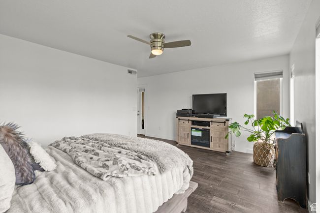 Bedroom with dark wood-style flooring and ceiling fan | Image 19