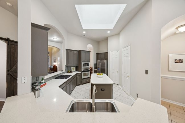 Thoughtfully designed for everyday function and entertaining, this kitchen offers dual sinks, generous counter space, and sightlines that keep you connected to the main living spaces. | Image 7