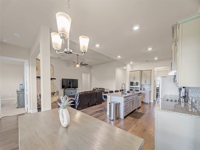 Dining room with ceiling fan, light wood-style flooring, recessed lighting, and a chandelier | Image 11