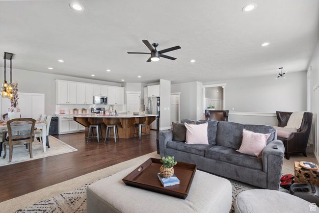 Living room featuring dark wood-style floors, a ceiling fan, recessed lighting, and a chandelier | Image 11