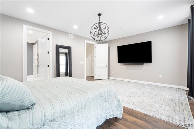 Bedroom with baseboards, dark wood-style floors, an inviting chandelier, and recessed lighting | Image 27