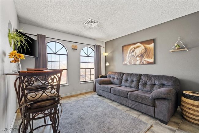 Living area featuring visible vents, a textured ceiling, and baseboards | Image 40
