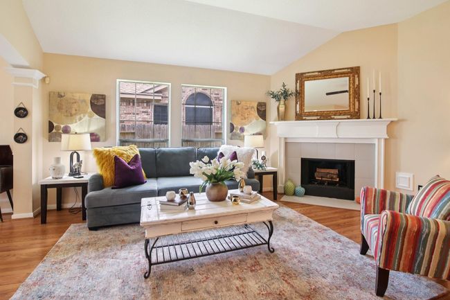 This cozy living room features a warm color palette with hardwood floors and large windows provide natural light. | Image 9