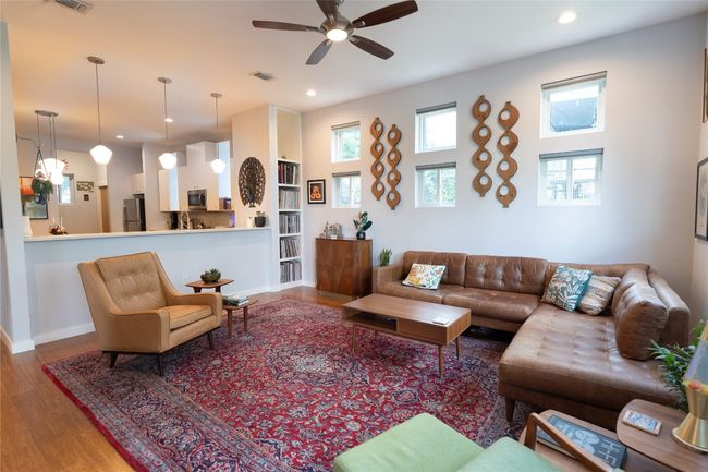 Living area with wood finished floors, a ceiling fan, recessed lighting, and built in features | Image 29