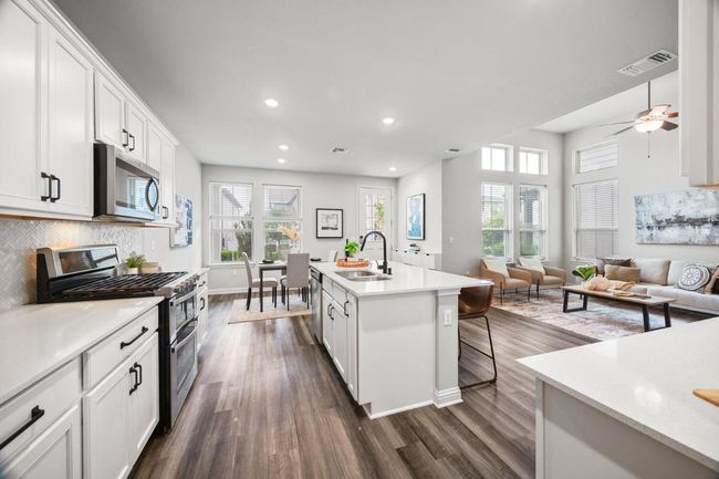 Kitchen featuring appliances with stainless steel finishes, a sink, healthy amount of natural light, dark wood-style floors, and recessed lighting | Image 4
