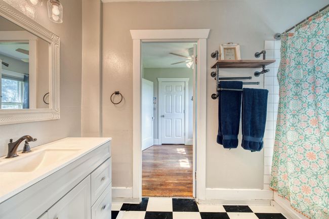Full bathroom featuring tile patterned floors, vanity, ceiling fan, and shower / bath combo with shower curtain | Image 25