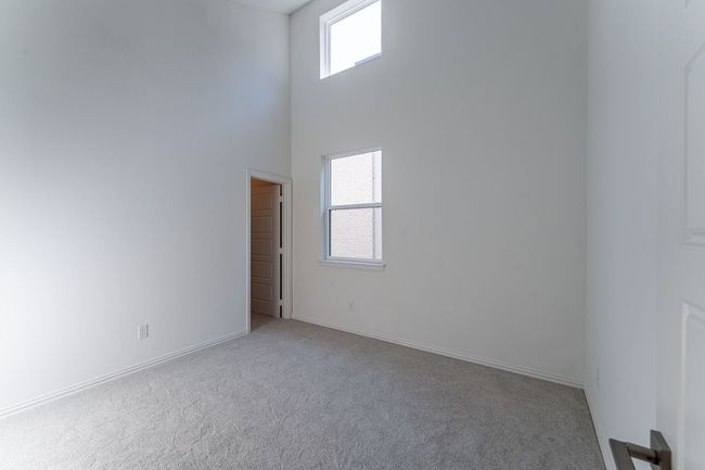 Empty room with carpet, a towering ceiling, and baseboards | Image 7