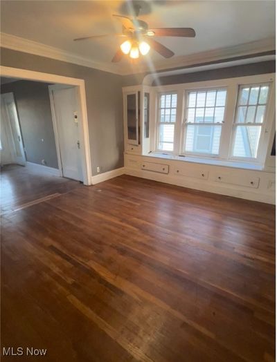 Unfurnished room with dark hardwood / wood-style flooring, ceiling fan, and ornamental molding | Image 3