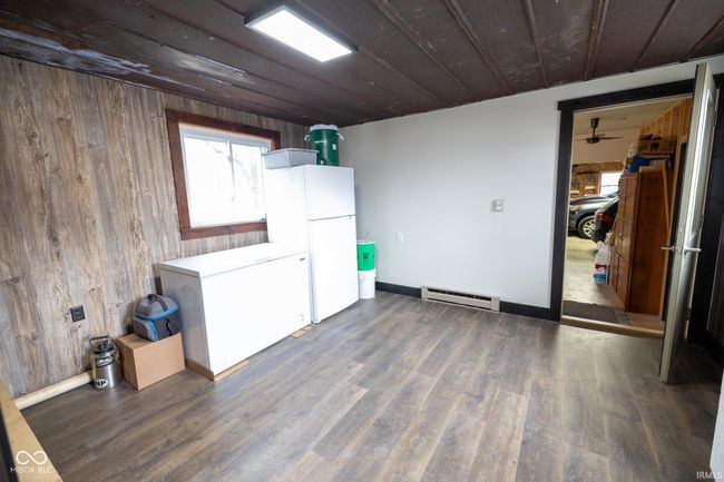 interior space with wooden walls, a baseboard radiator, and a healthy amount of sunlight | Image 12